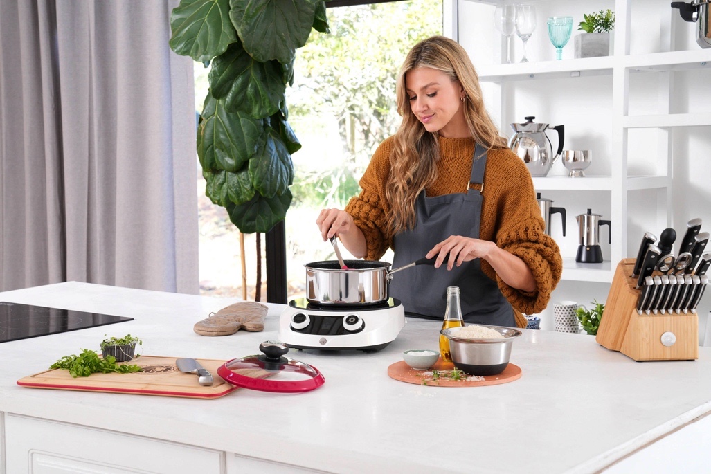 A woman cooking with Royal Prestige products.